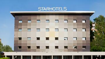 Un edificio de StarHotels de diseño moderno, con numerosas ventanas y un cielo despejado.