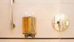 A bathroom with a chrome shower handle, two bottles of Stannotel's body lotion, and a round chrome faucet. - Starhotels Tourist (Milan)