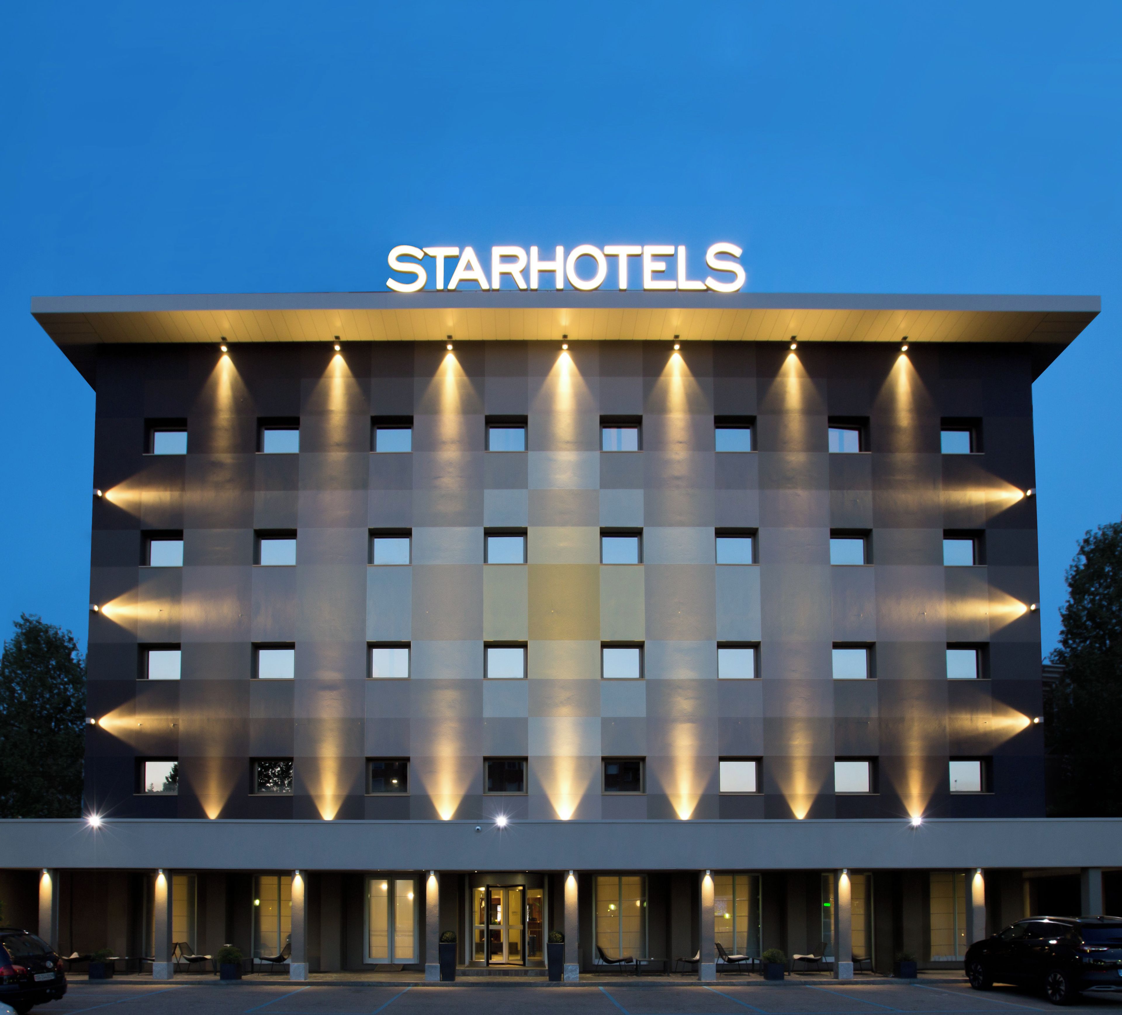 A hotel with a modern facade, multiple windows, and a prominent 'STARHOTELS' sign.