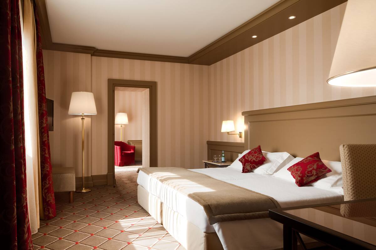 Une chambre d’hôtel avec un grand lit, des tables de chevet, un bureau et une chaise.