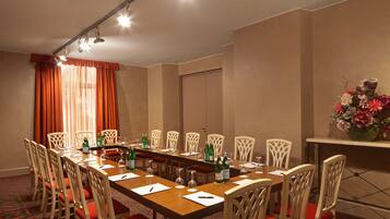 A conference room with a long table, chairs, and a floral arrangement.