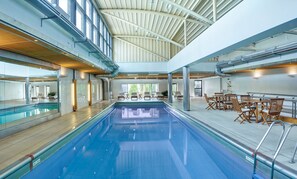 Una piscina interior con techos altos y luz natural.