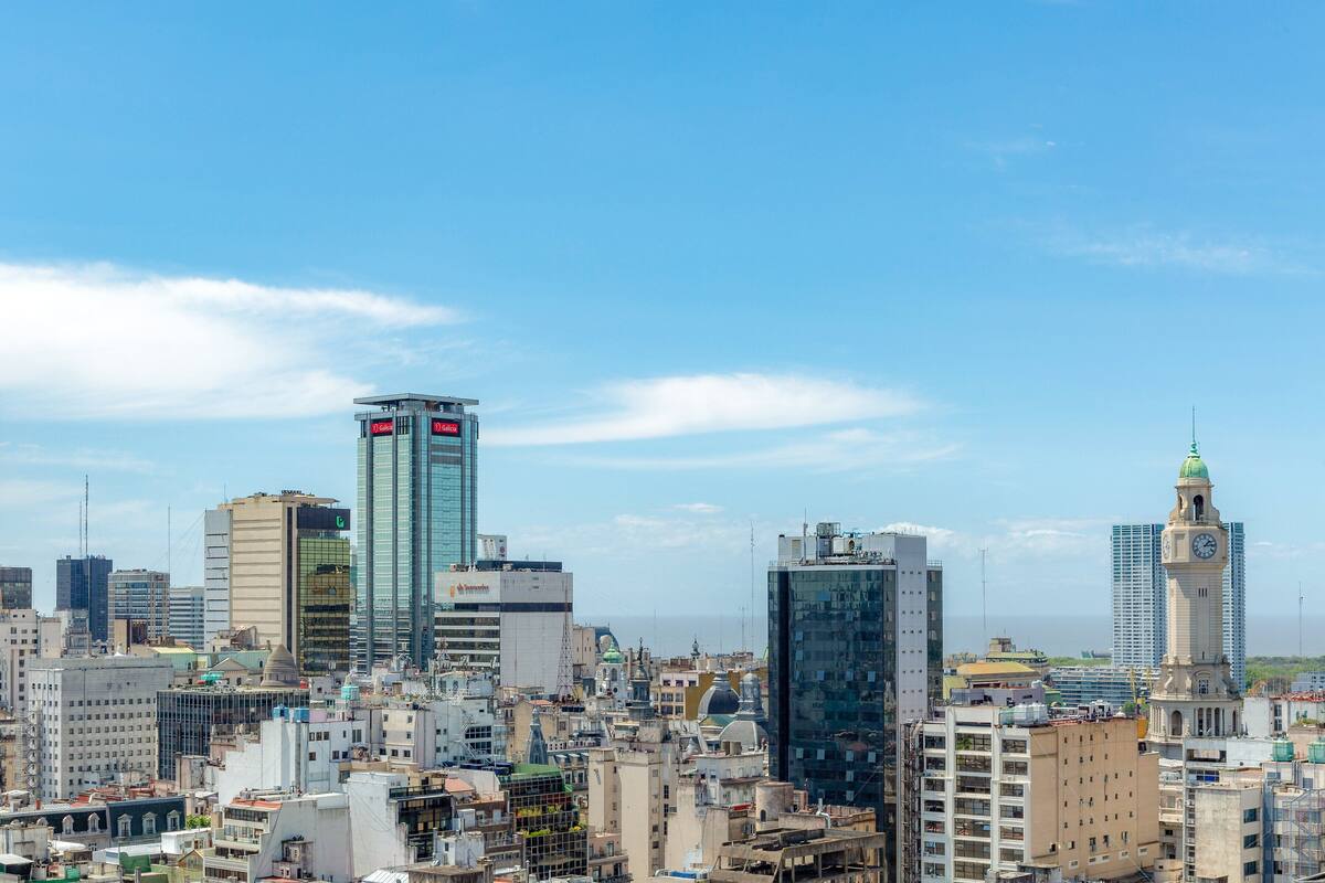A cityscape with various buildings, including a clock tower and modern skyscrapers.