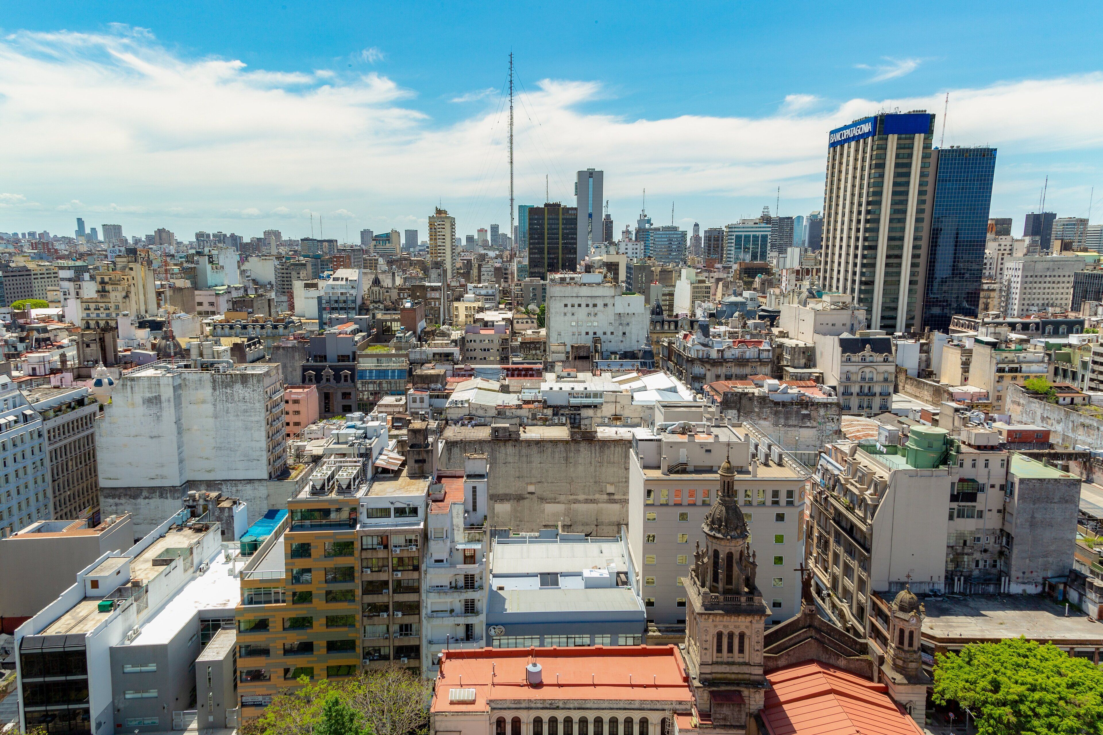 A dense urban cityscape with a variety of building styles, including modern high-rises and older, smaller structures.