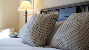 A neatly made bed with patterned pillows and a headboard.