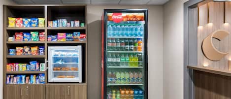 A vending machine and snack shelves in a hotel lobby.
