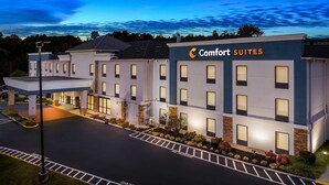Un hotel Comfort Suites con un diseño moderno, que presenta una entrada cubierta y una fachada bien iluminada.
