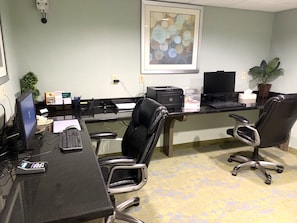 Work in comfort with a long desk, two office chairs, and a computer.