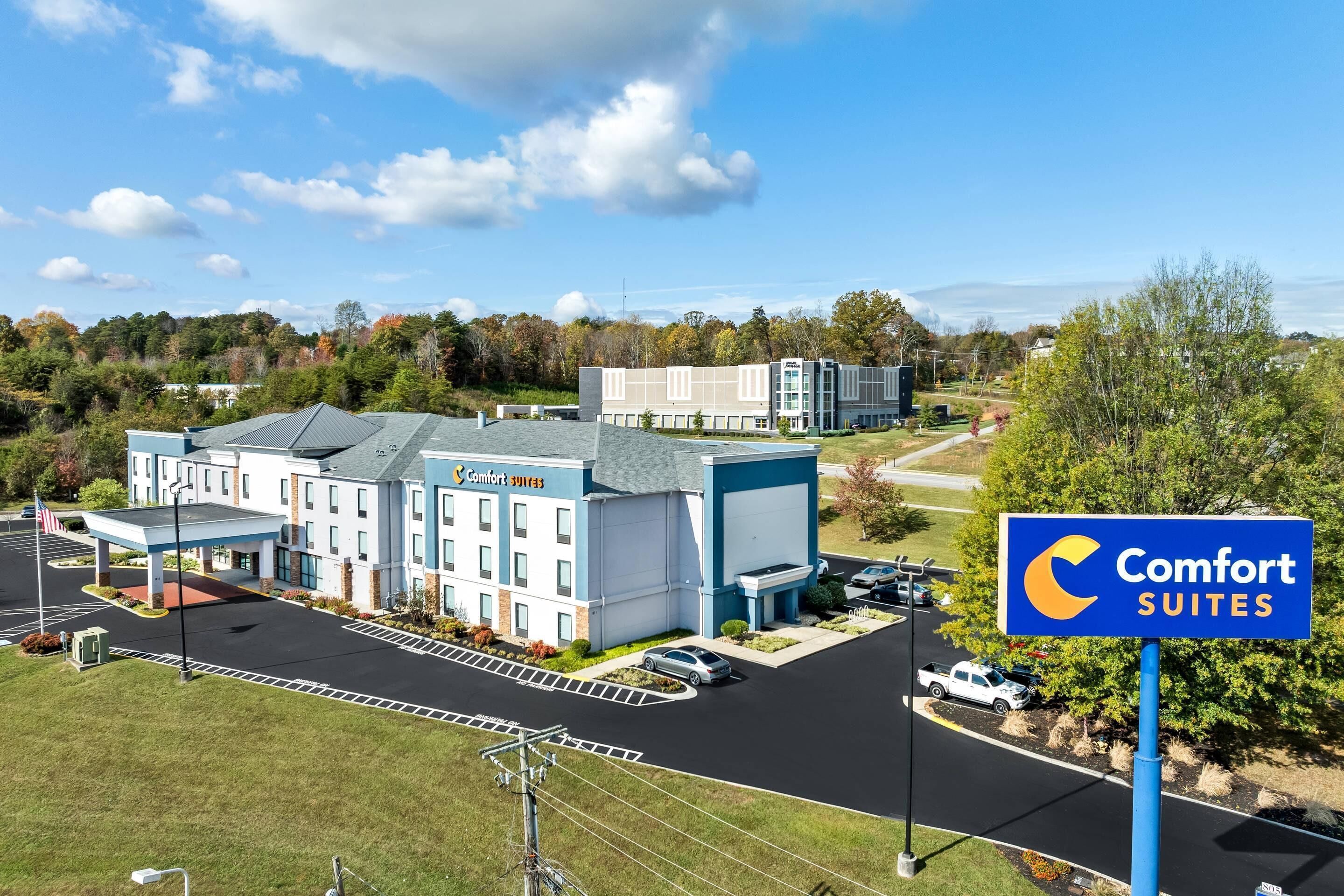 Comfort Suites -hotelli, jossa on pysäköintialue, huoltoasema ja näkymät ympäröivään alueeseen.