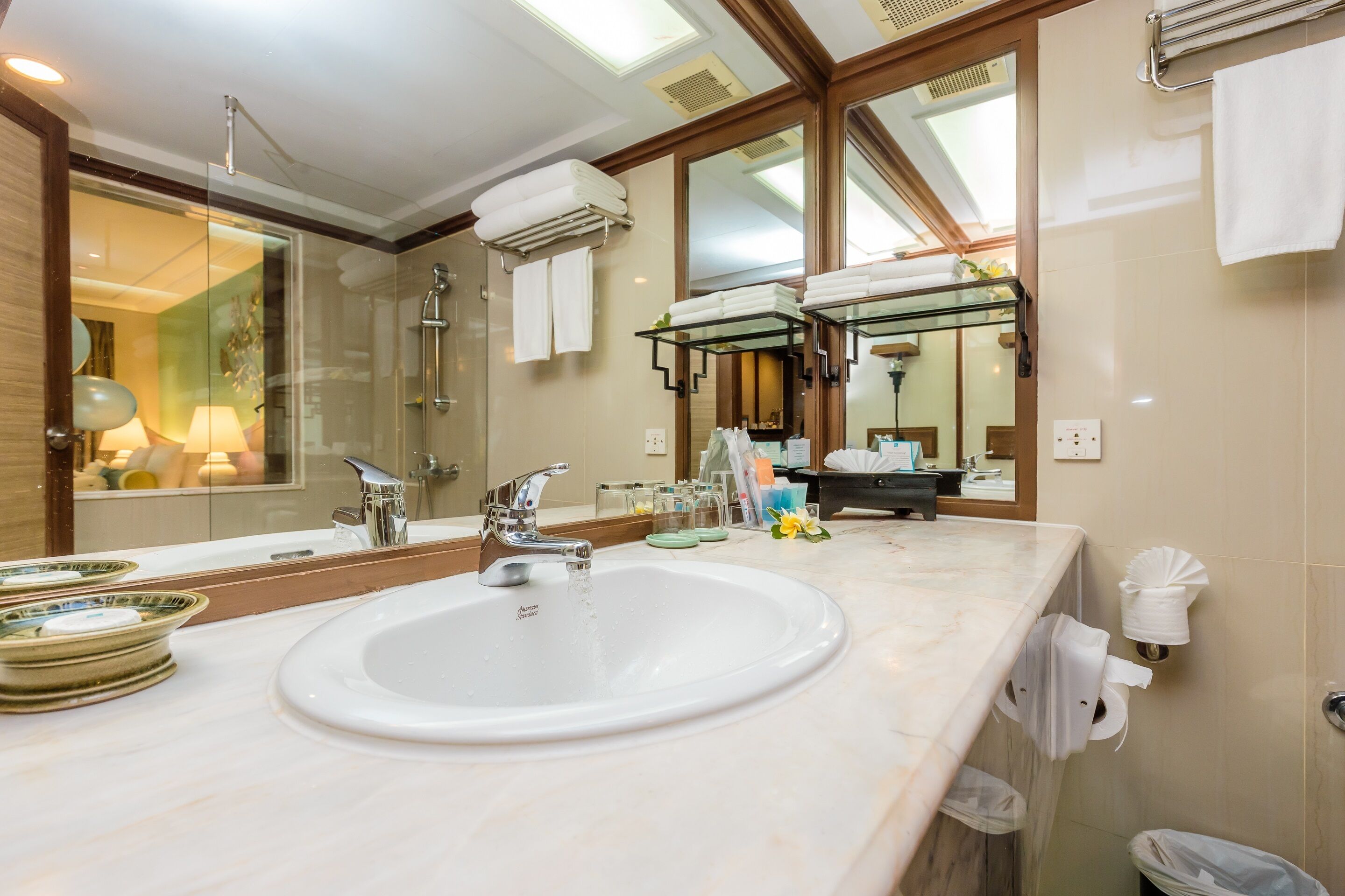 A modern bathroom with a large mirror, a sink, and a glass shower enclosure.