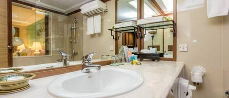 A modern bathroom with a large mirror, a sink, and a glass shower enclosure.