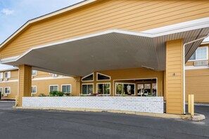 A hotel with a flat roof, large windows, and a brick facade.