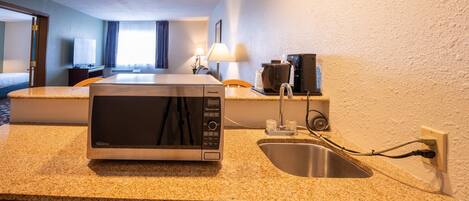 A compact kitchen with a microwave, sink, and dishwasher.