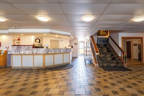 A reception area with a marble counter, a staircase, and a herringbone patterned floor. - Quality Inn Paradise Creek Pullman (Pullman)