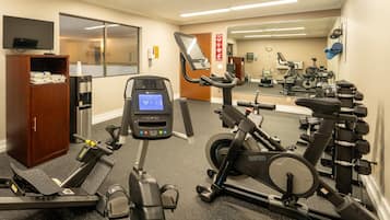 A gym with various exercise equipment, including treadmills, stationary bikes, and weight machines.