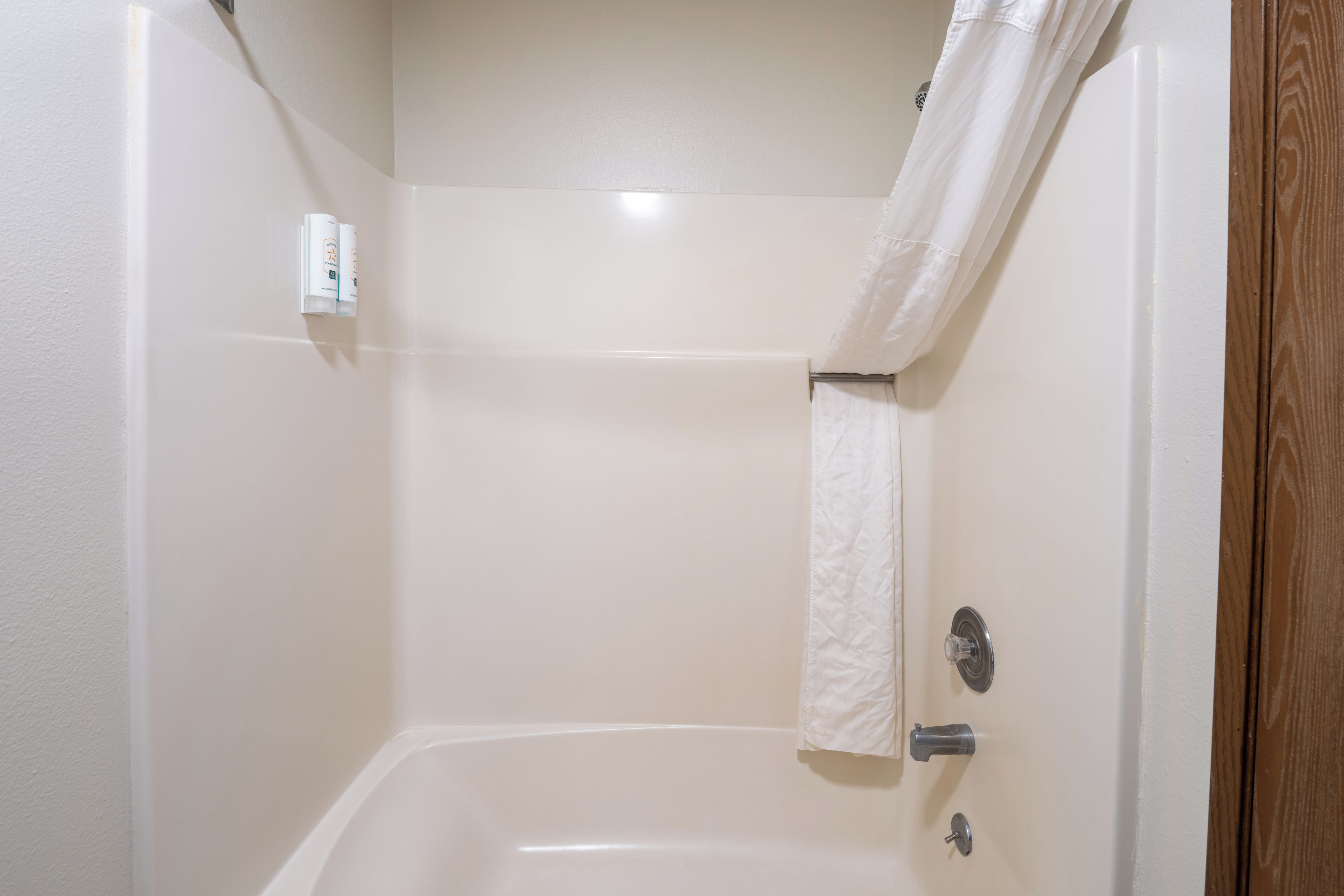 A bathroom with a bathtub, a shower curtain, and a towel rack.