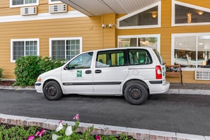 A white van parked in front of a yellow building with multiple windows and a visible awning. - Quality Inn Paradise Creek Pullman (Pullman)
