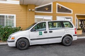 A white van parked in front of a building with a sign for Quality Inn Paradise Creek. - Quality Inn Paradise Creek Pullman (Pullman)