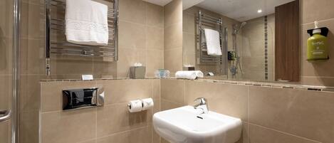 A modern bathroom with a glass shower enclosure, a white sink, and a mirror above the sink.