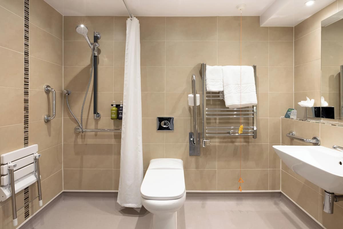 A modern bathroom with a shower, toilet, and sink.