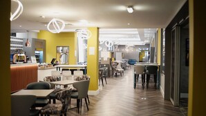 Um interior moderno com área de bar, assentos e padrão de piso em espinha de peixe.
