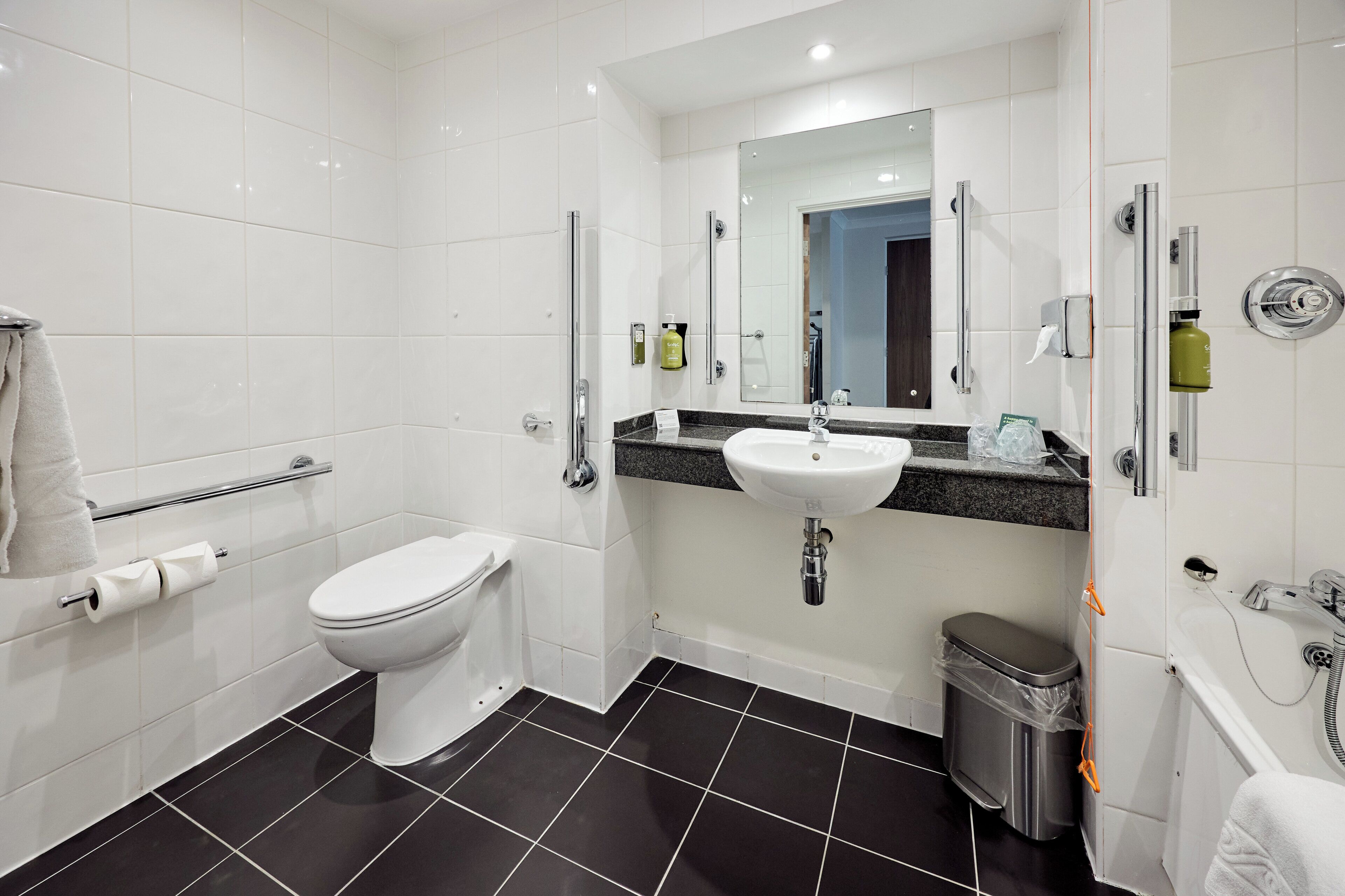 A modern bathroom with a toilet, sink, and shower.