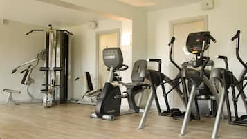 Une salle de sport à domicile équipée de divers appareils d’exercice, notamment un tapis de course, un vélo elliptique et une machine de musculation.