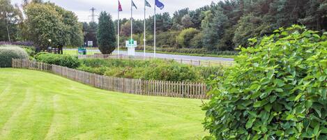 A well-maintained lawn, a wooden fence, and a sign for a Holiday Inn.