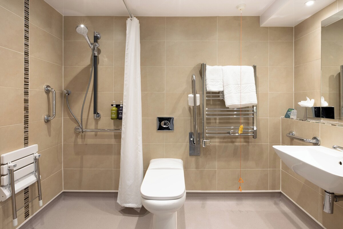 A modern bathroom with a shower, toilet, and sink.