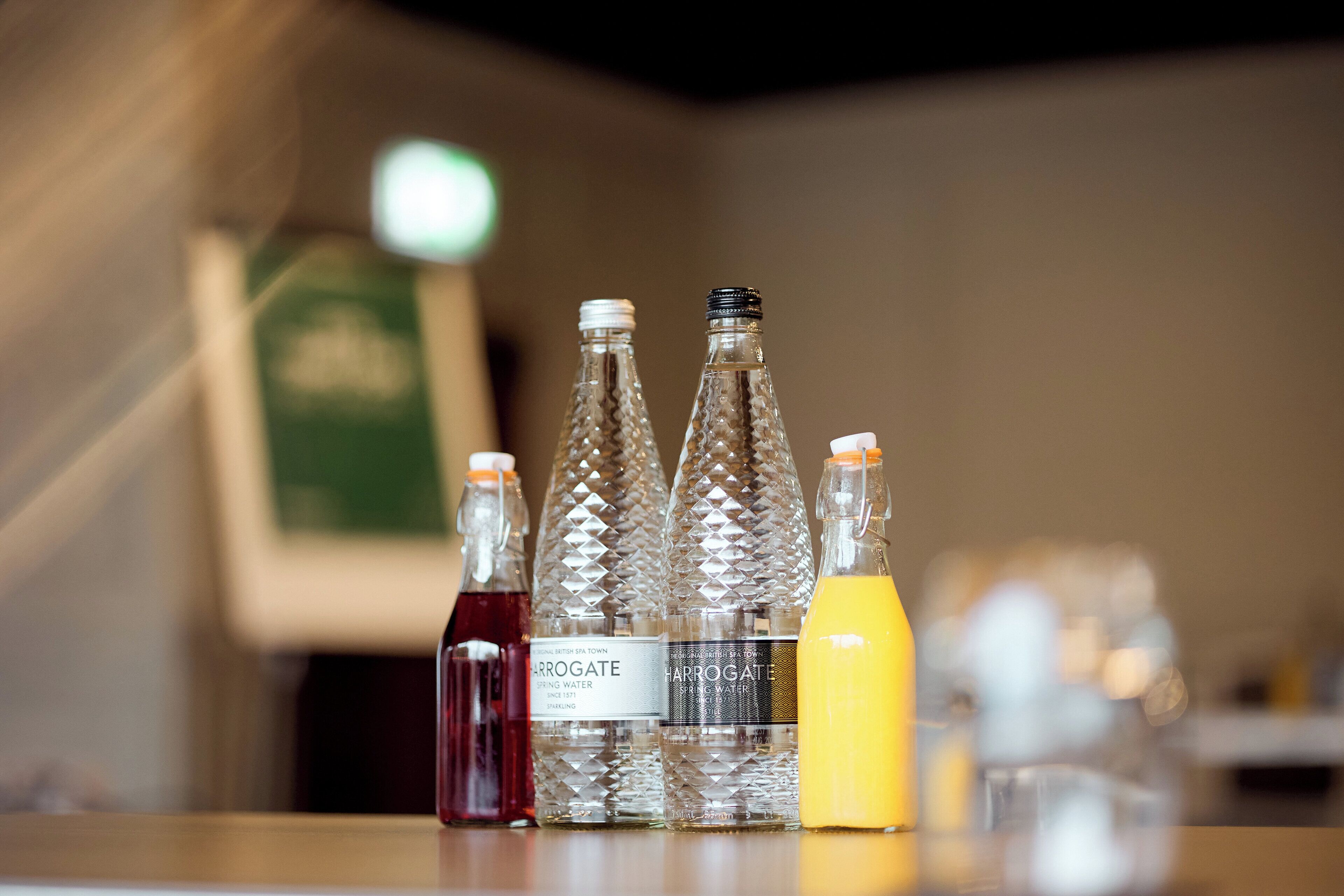 Four glass bottles with labels on a table.