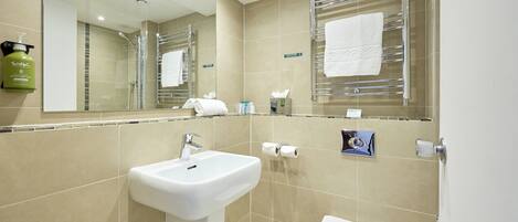 A modern bathroom with a sink, toilet, and towel rack.