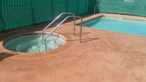 A swimming pool with a concrete deck and metal handrails. - Ocean Gateway Inn (Santa Paula)