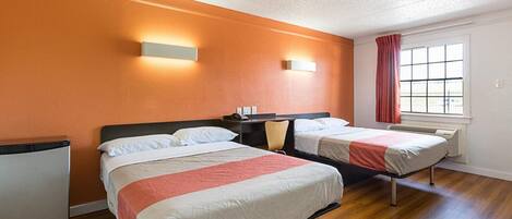 Une chambre d’hôtel avec deux lits, un bureau, une chaise, une fenêtre donnant sur un paysage agréable et un luminaire au plafond.