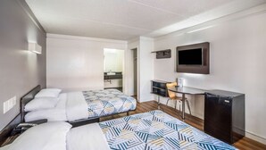 A hotel room with two beds, a desk, a chair, a television, and a refrigerator. - Motel 6 Dallas, TX - Market Center (Dallas)