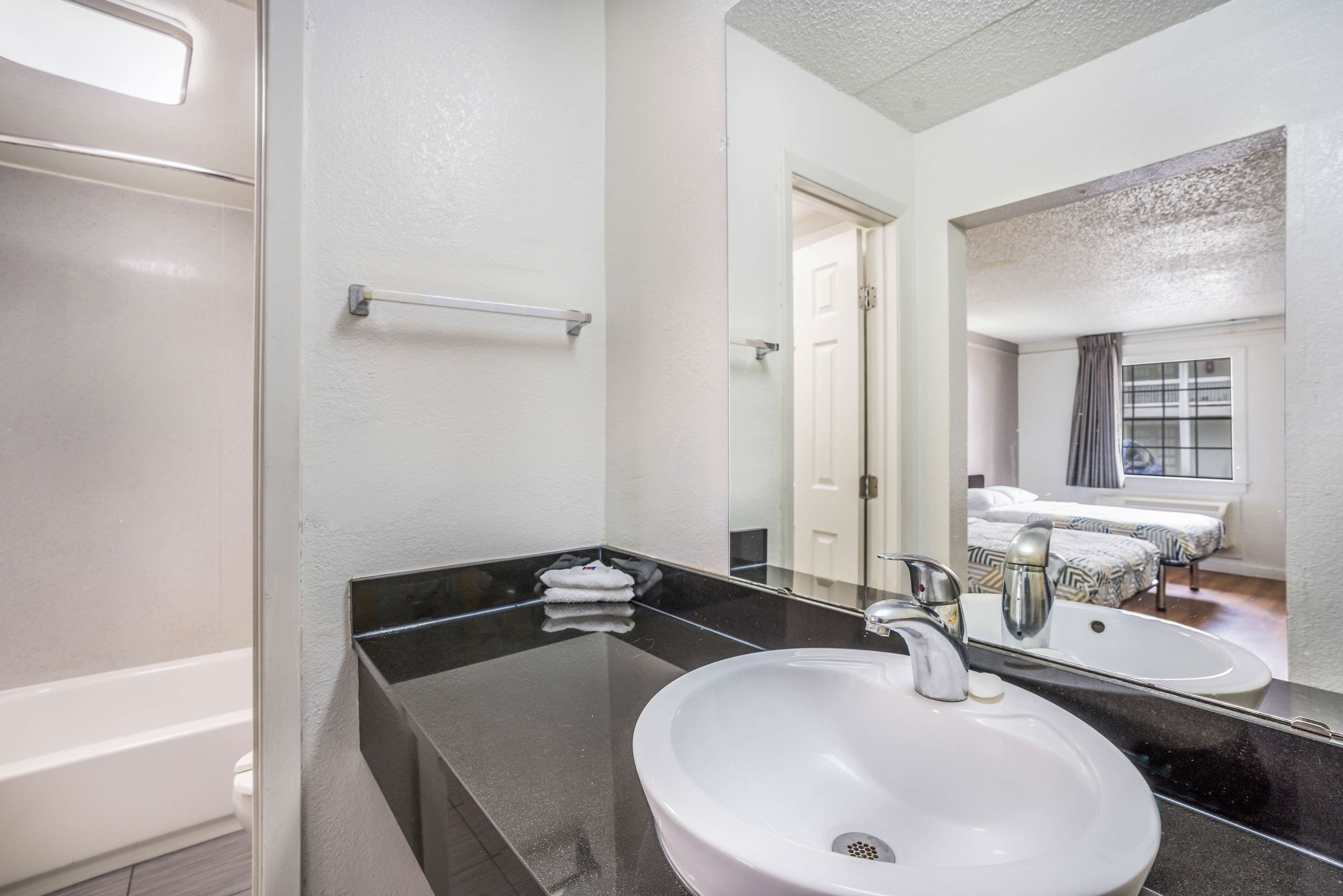 A bathroom with a white sink, a mirror, and a glass shower enclosure.