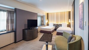 Een hotelkamer met een bed, een televisie, een bureau en een stoel.