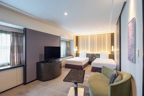 Ein Hotelzimmer mit Bett, Fernseher, Schreibtisch und Stuhl.
