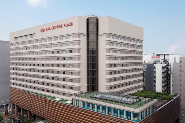 A multi-story hotel with a prominent sign reading 'ANA CROWNE PLAZA'.