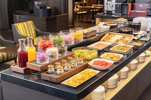 A buffet with various food items and condiments.