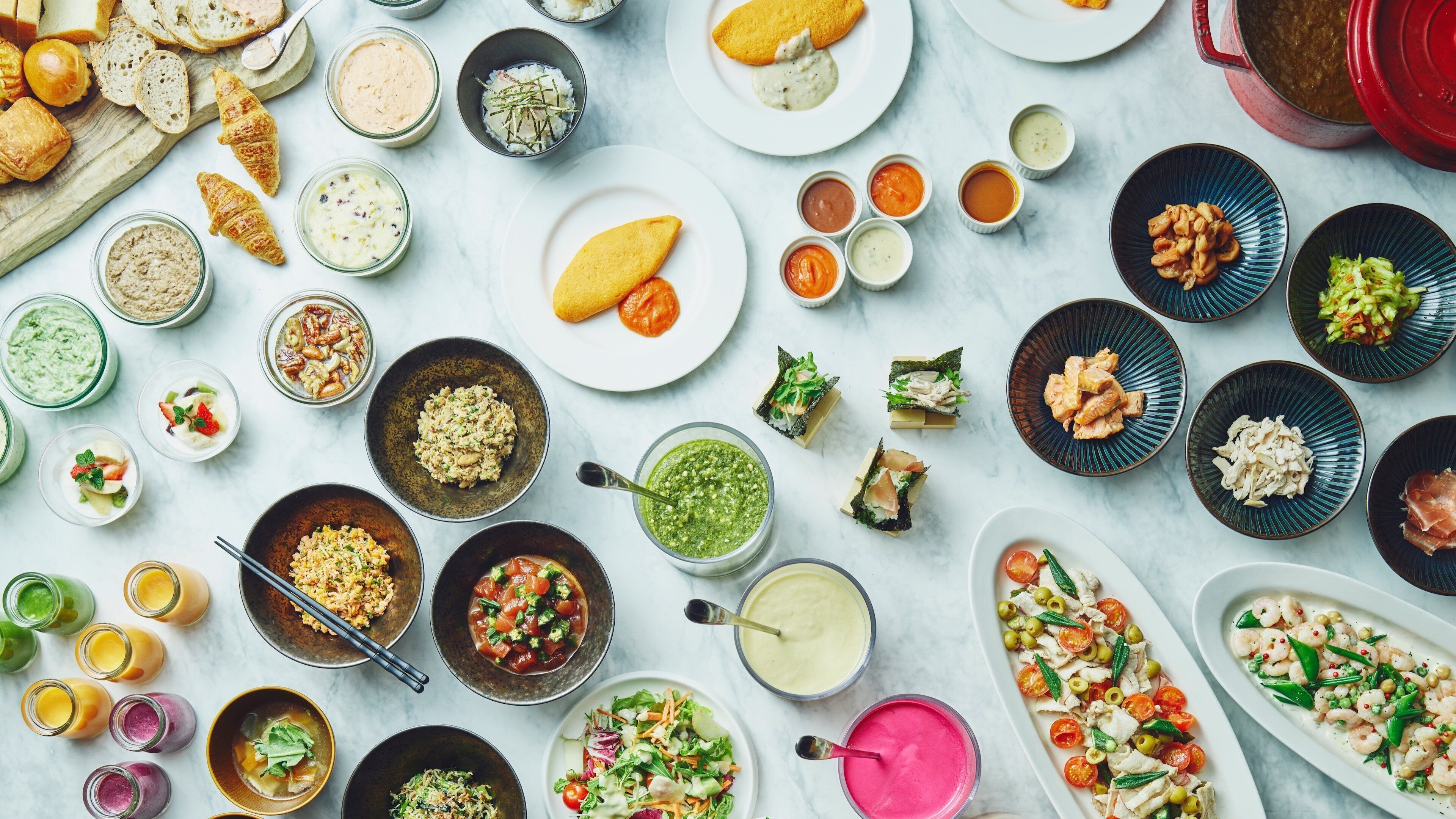 Diversos pratos e alimentos dispostos sobre uma mesa.
