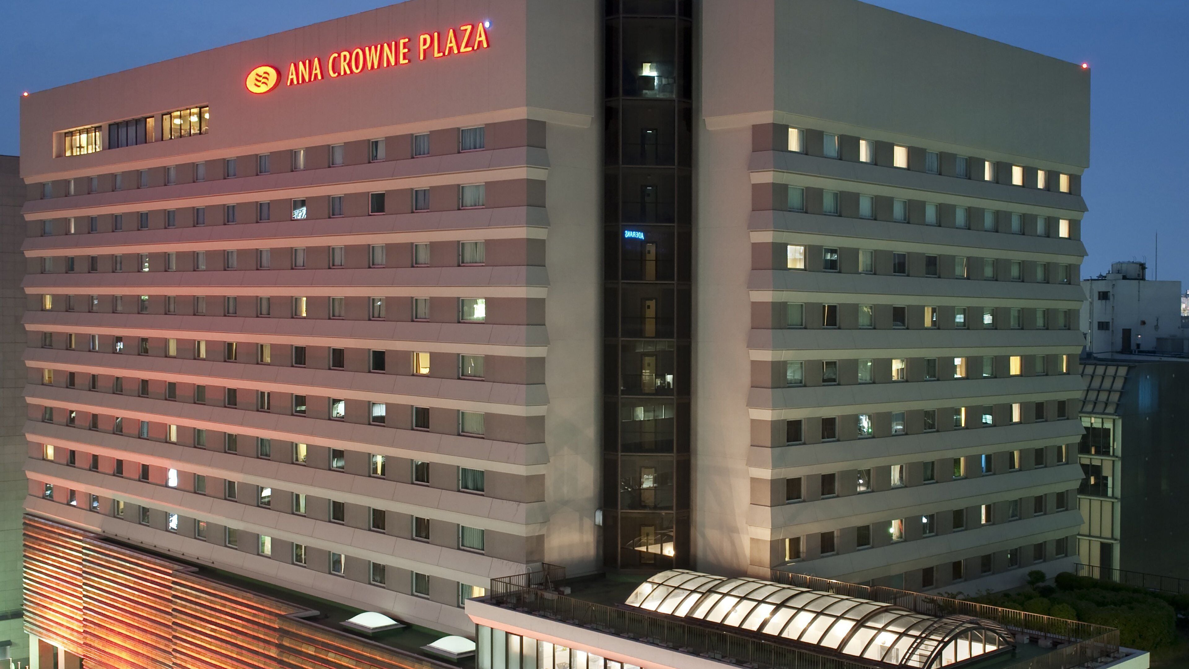 A multi-story hotel with a prominent sign reading 'ANA CROWNE PLAZA'.