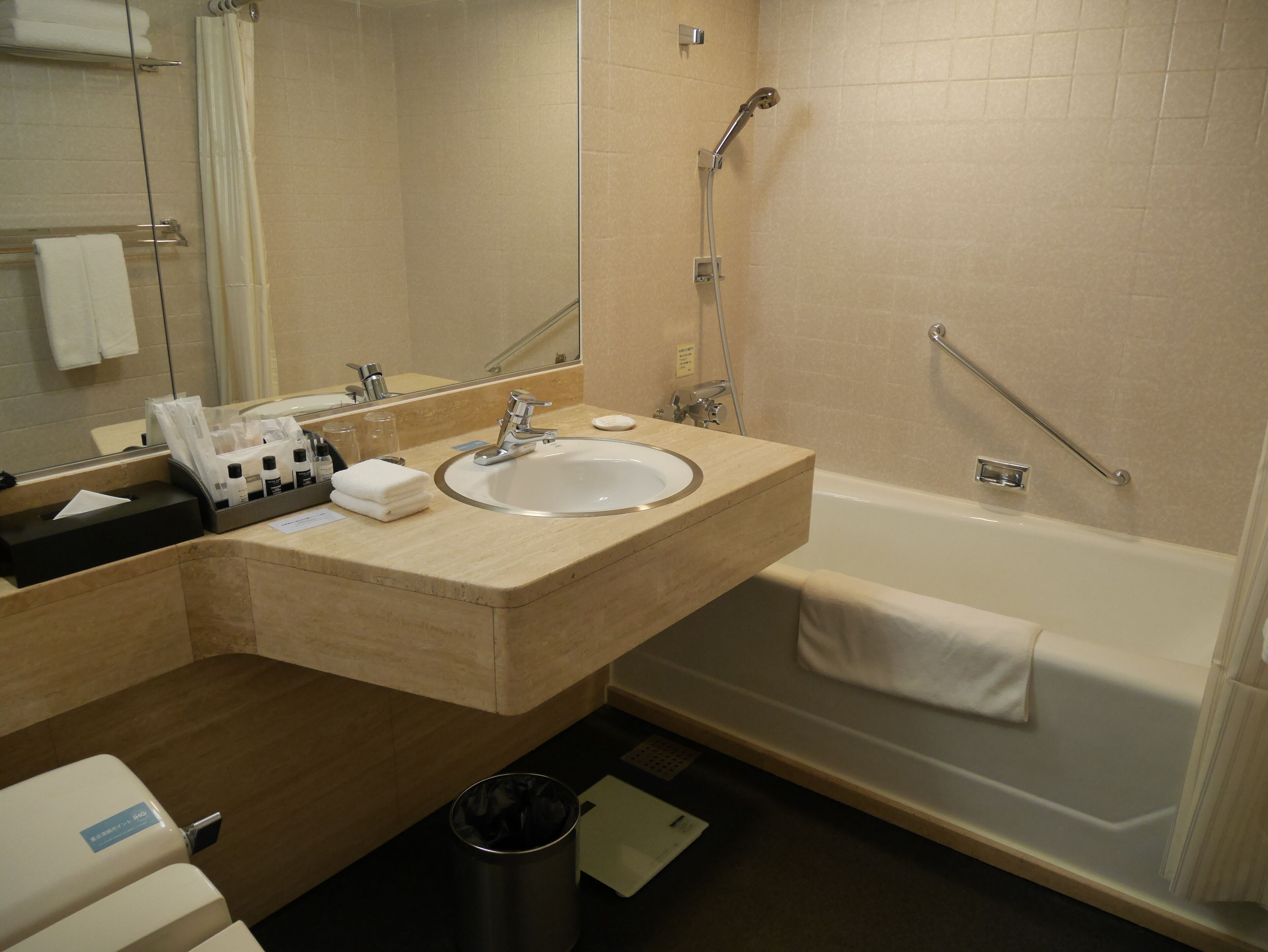 Un baño moderno con lavamanos, espejo y ducha.