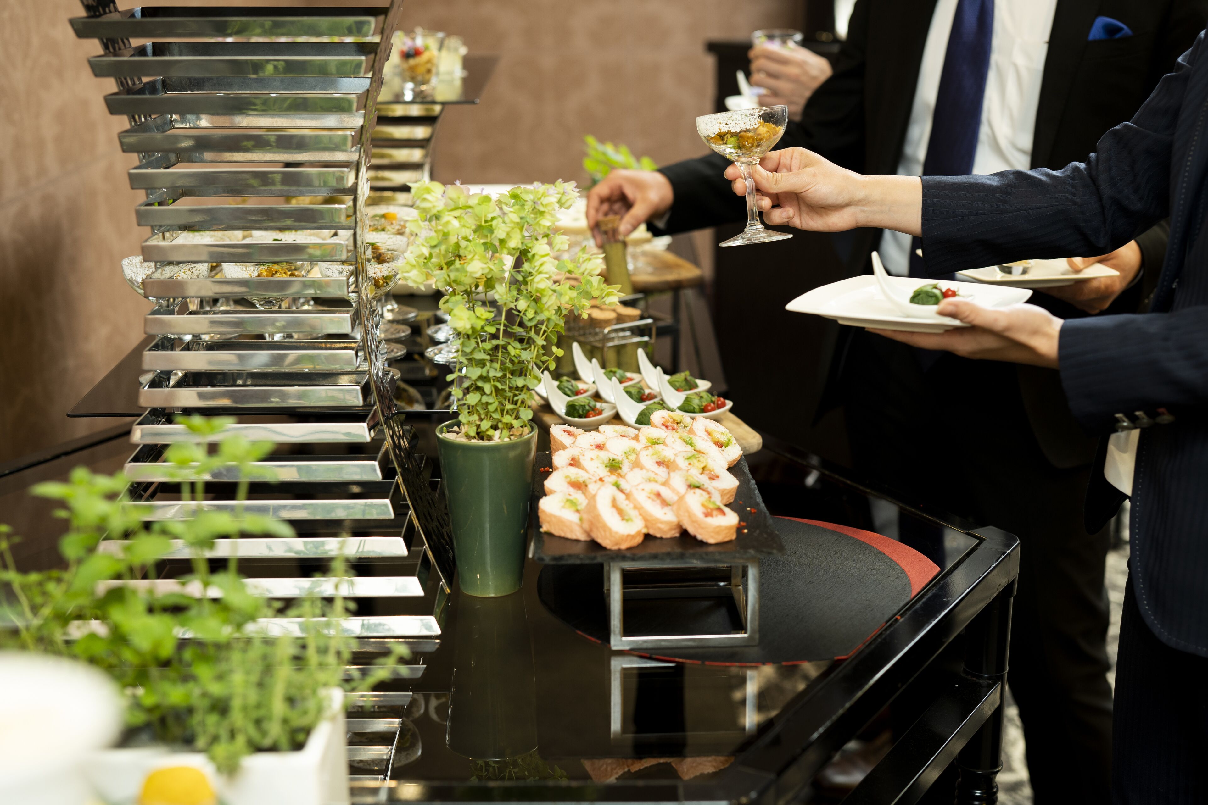 Un buffet proposant une variété de plats et agrémenté d’une plante verte en guise de décoration centrale.
