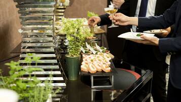 A buffet setup with various food items and a green plant centerpiece.