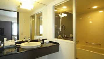 A modern bathroom with a large mirror, a sink, and a shower.