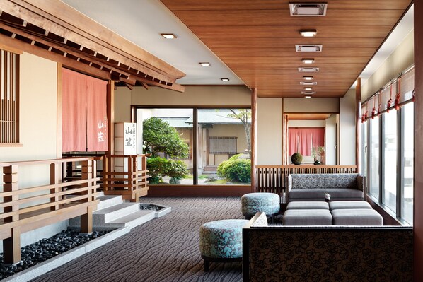A traditional Japanese-style interior with tatami flooring, a low wooden bench, and a view of a garden through large sliding doors. - ANA Crowne Plaza Fukuoka by IHG (Fukuoka)