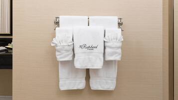 A set of white towels with the text "The Raphael Hotel" hanging on a wooden wall.