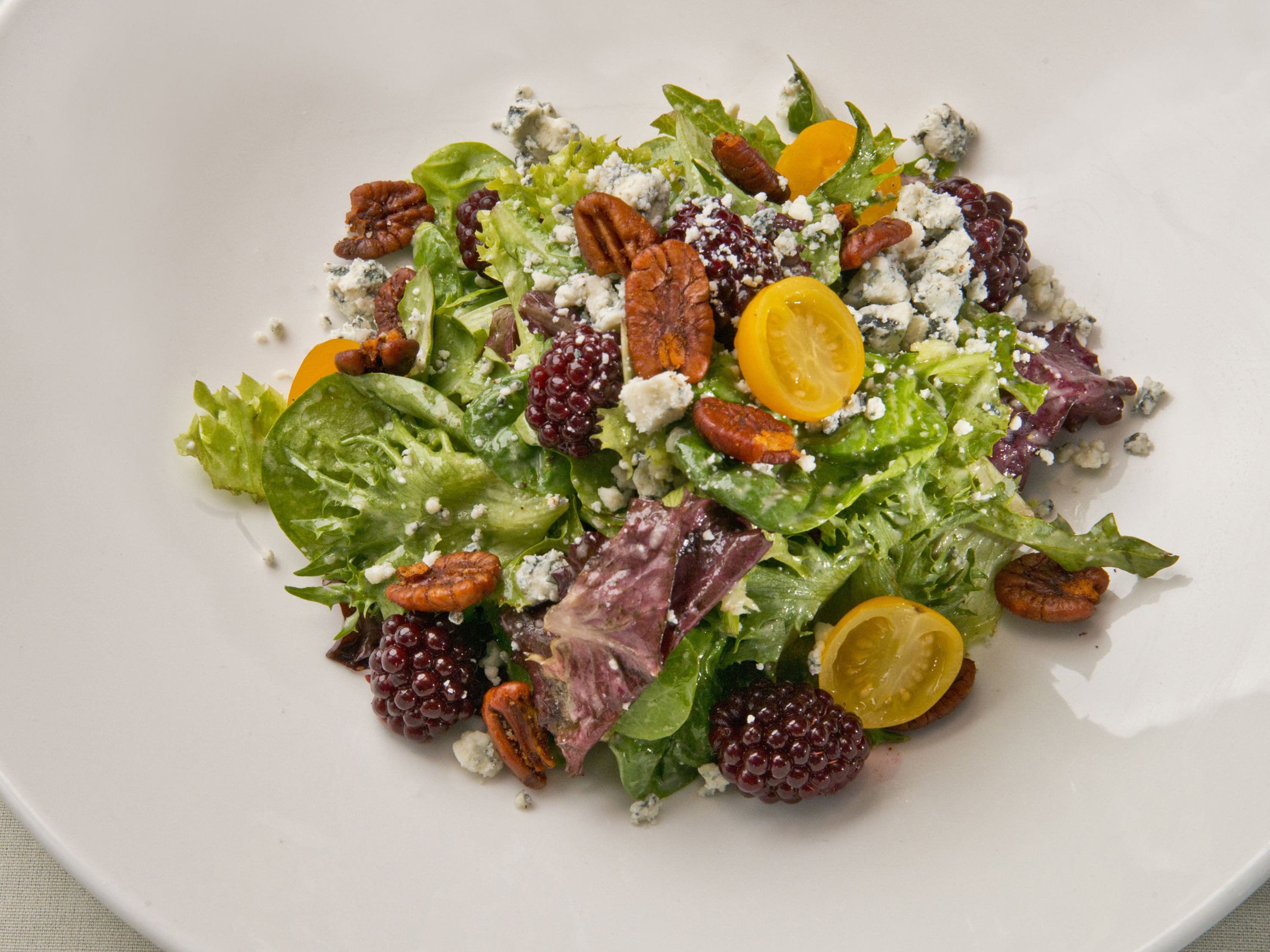 A salad with various ingredients on a white plate.