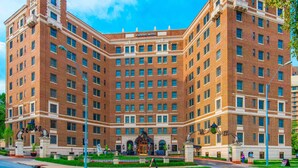 A large, multi-story brick building with a central entrance and a sign reading "Raphael Hotel."