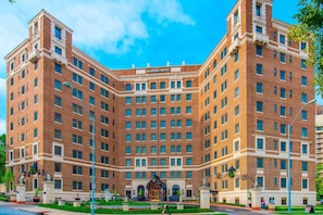 A large, multi-story brick building with a central entrance and a sign reading "Raphael Hotel."